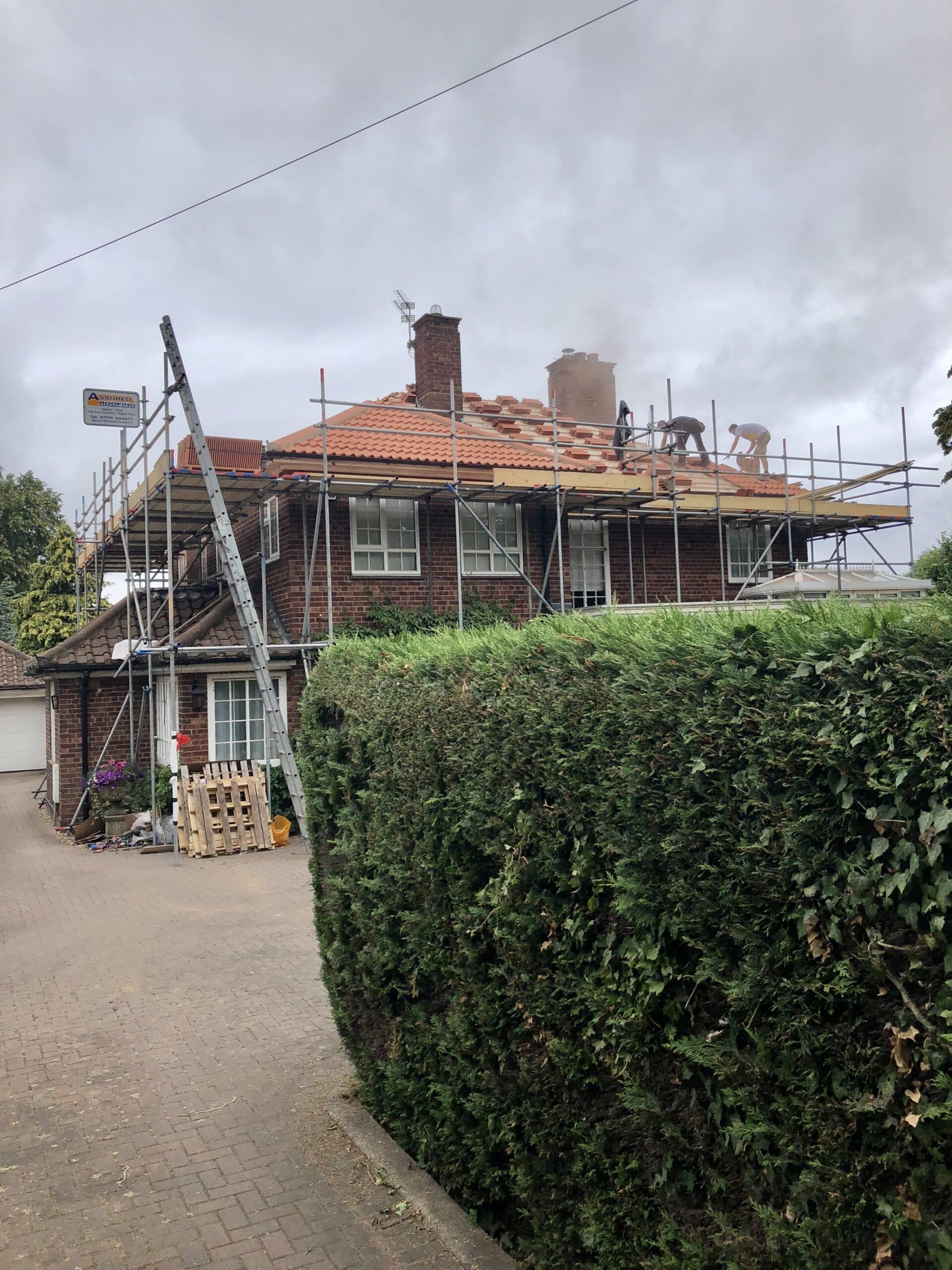 clay roof tiles being installed on a traditional property with mortar ridges